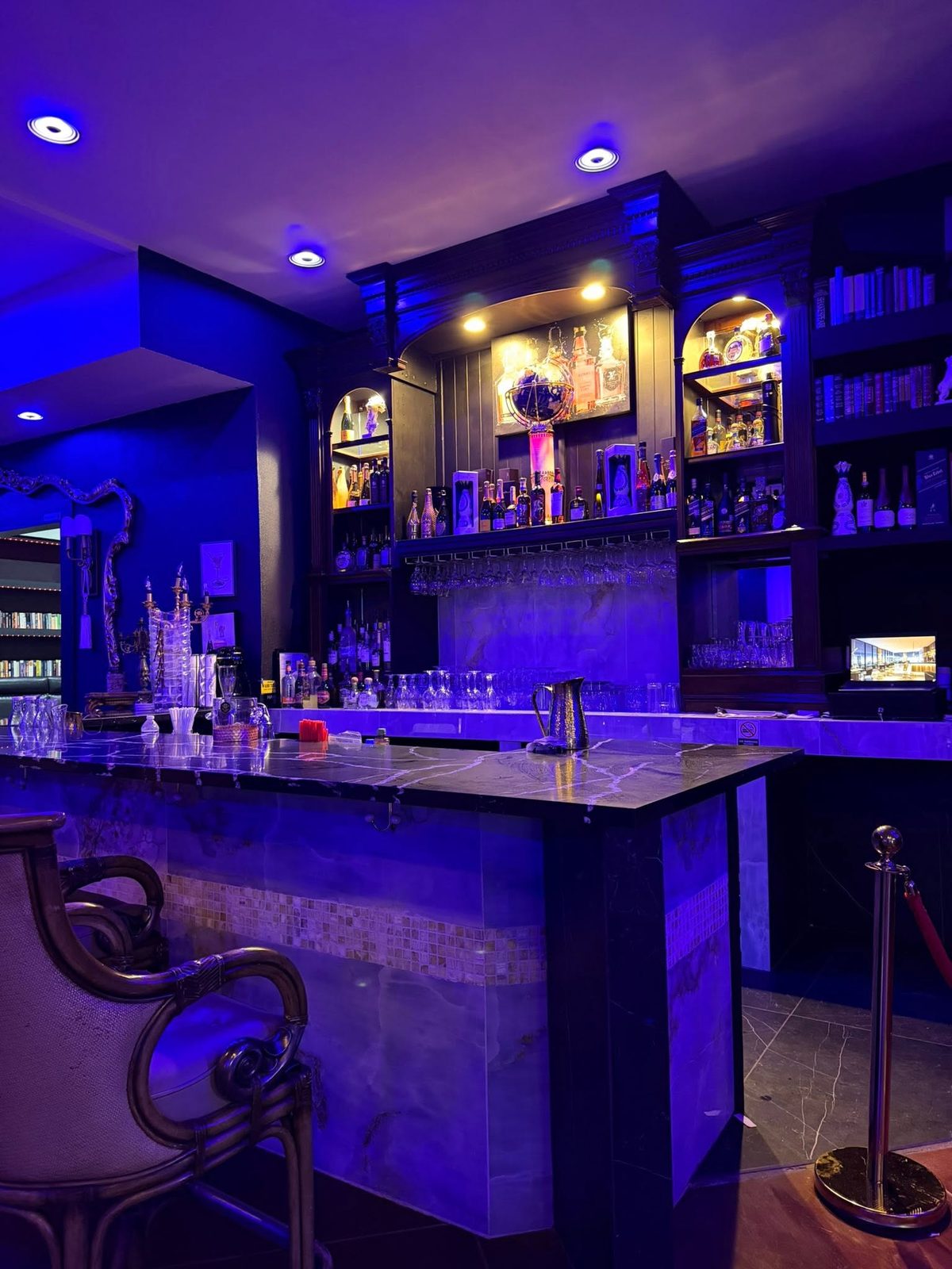 The bar at Bobby's Steakhouse lit in violet and gold